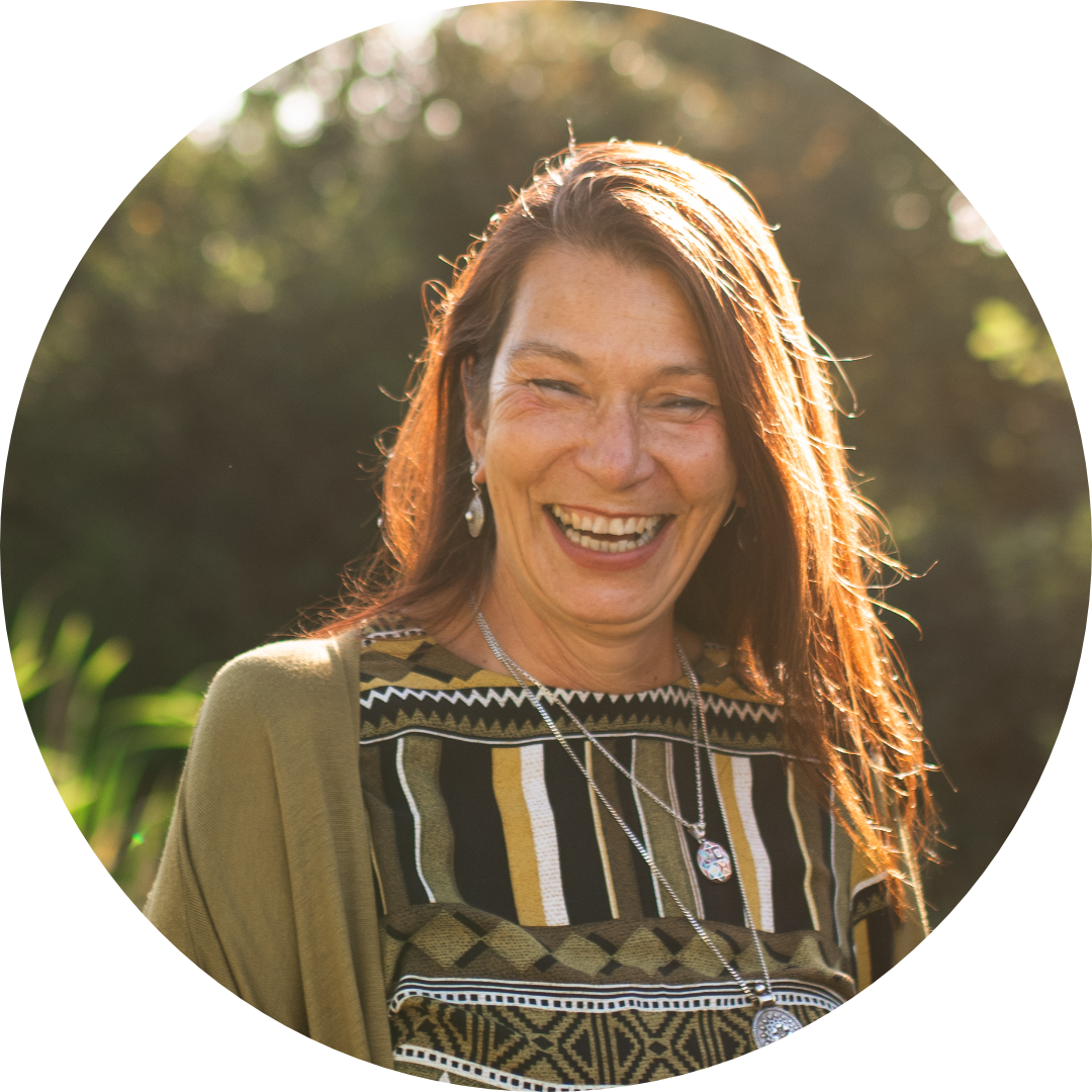 Foto von mir, Eisabeh Vogl, im Garten stehend, mit hochgesteckten Haaren, einer weißen, großen Bluse und einer violetten Leggins.